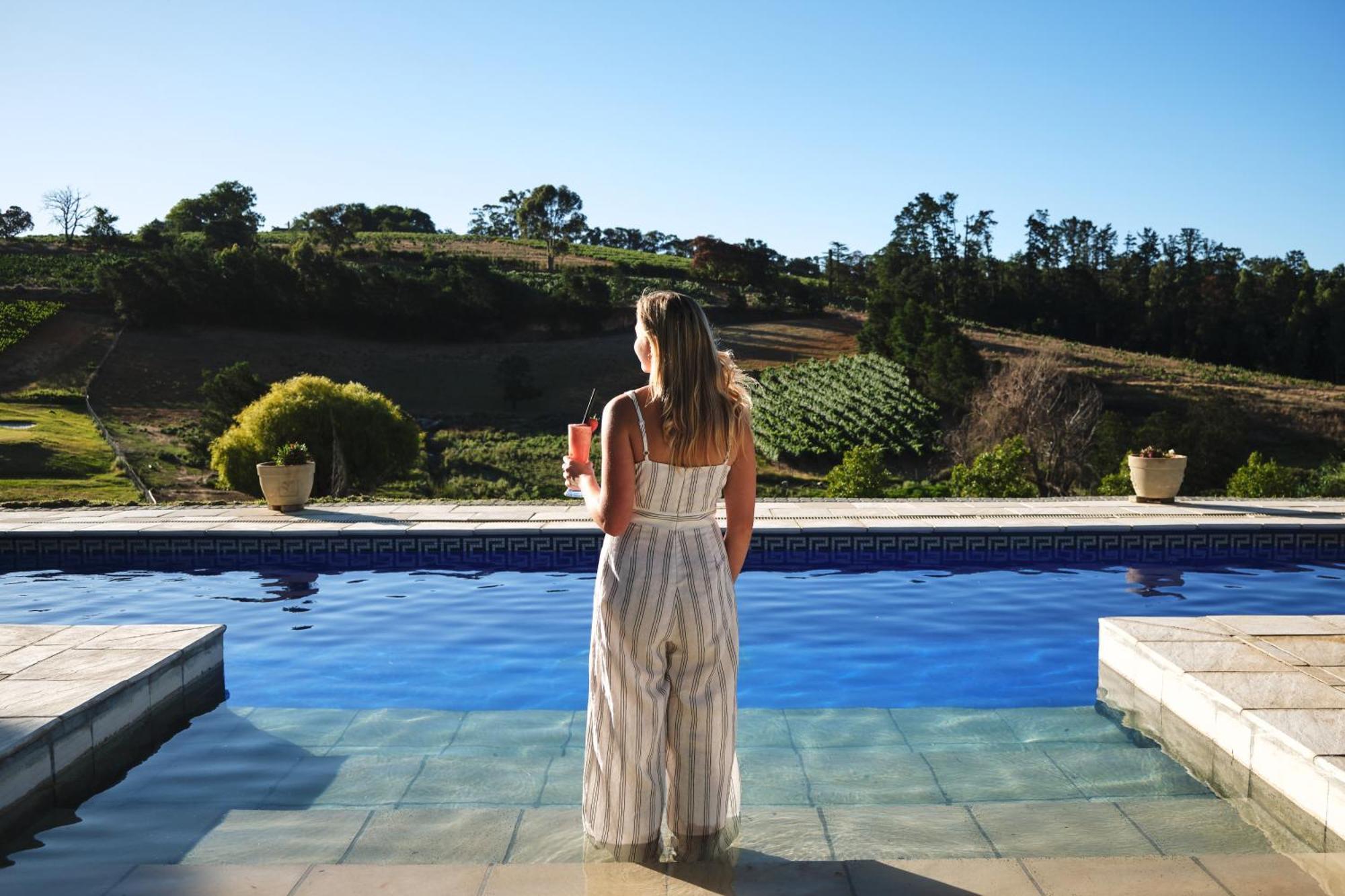 Alluvia Boutique Winery & Luxury Accommodation Stellenbosch Ruang foto A woman standing by a pool